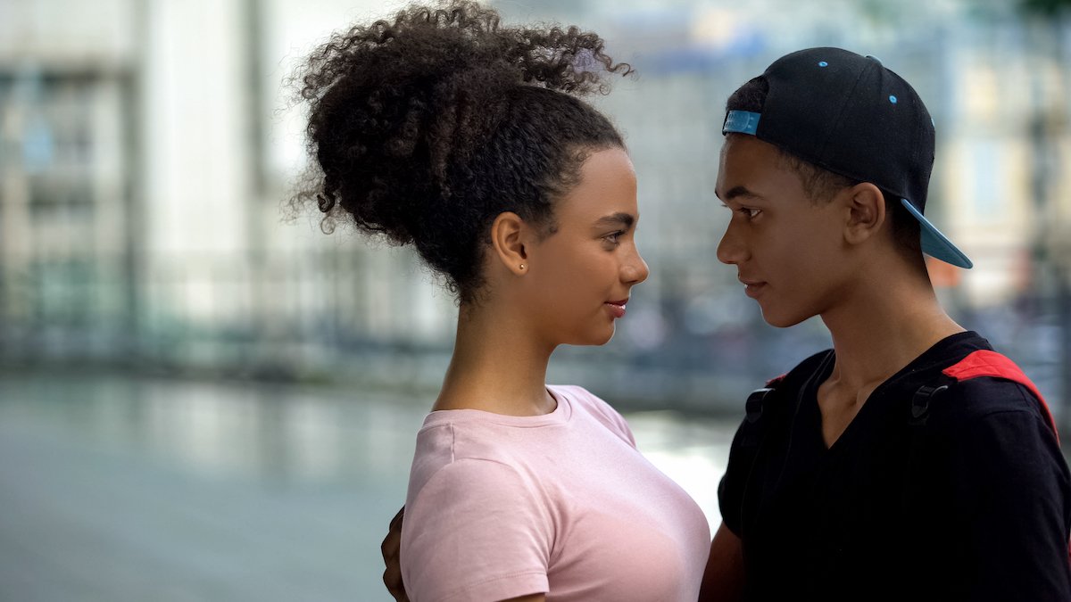 Two young teenagers looking at each other lovingly 