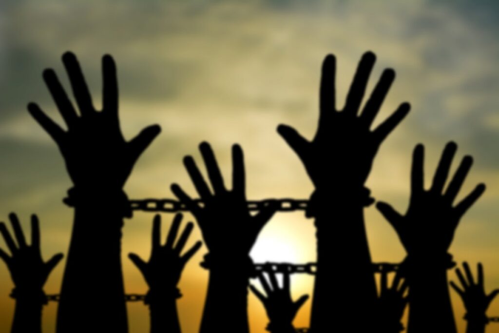 Silhouette of hands in chains reaching out to the sky